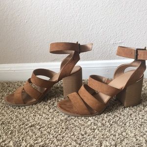 Beige strappy sandals with a thick heel.